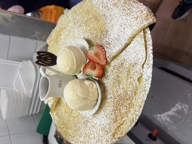 Verse pannenkoek met poedersuiker, twee bollen ijs en aardbei